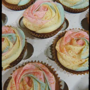 Pastel rose-swirled cupcakes in a box