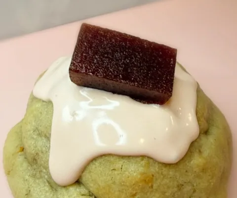 Guava stuffed cookie topped with cream drizzle and a slice of guava paste