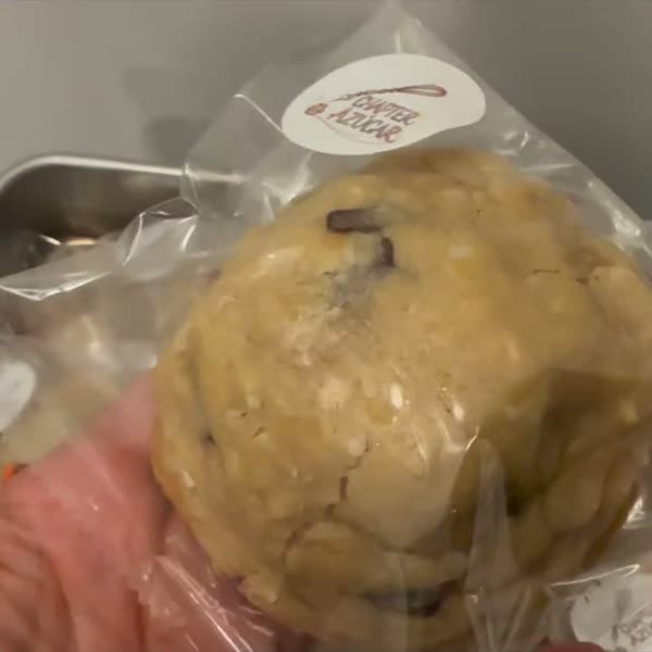 Individually wrapped cookies with Chapter Azúcar stickers held up one by one